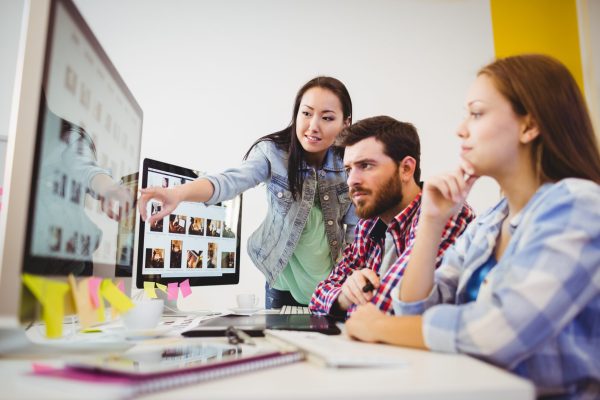 Businesswoman showing computer screen to coworkers local seo