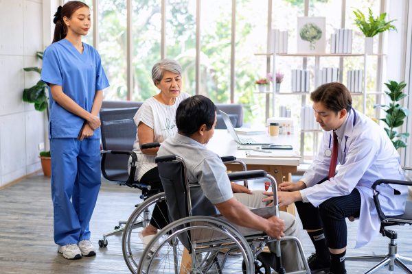 Senior couple male on wheel chair having consultations with doctor for knee problems at clinic health care